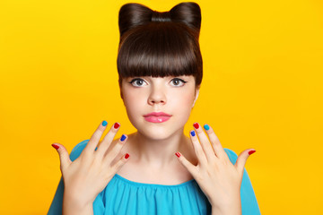 Makeup. Beautiful teen girl with bow hairstyle and multicolor ma