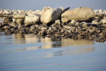 scogli riflessi nel mare in inverno con la bassa marea