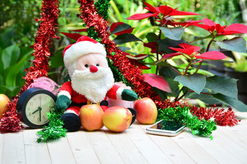 Santa Claus doll, apples and smart phone on Christmas day.