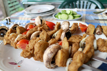 Vegetarian skewers of seitan, tomatoes and mushrooms