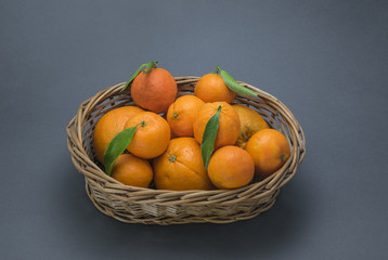 Oranges and mandarins with basket on blue background