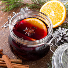 Christmas drink with orange fruit, anise, cinnamon and cloves on wooden table
