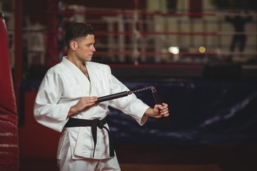 Karate player practicing with nunchaku