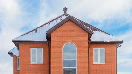 brick apartment house with a snow-covered roof