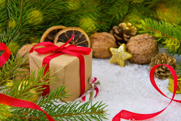 Christmas gift with red ribbon on snow background.