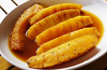 Slices of roasted caramelized pineapple in caramel sauce