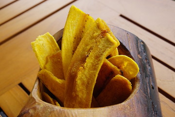 Fried plantain chips in a wooden bowl © eqroy