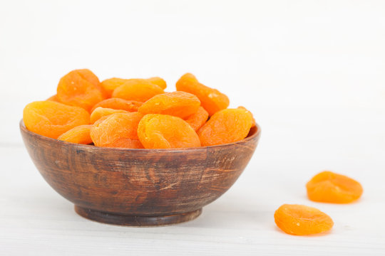 Natural organic dried apricots in wooden bowl