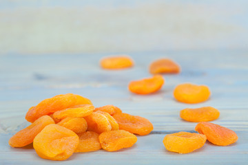 Pile of healthy, delicious dry apricots on blue table