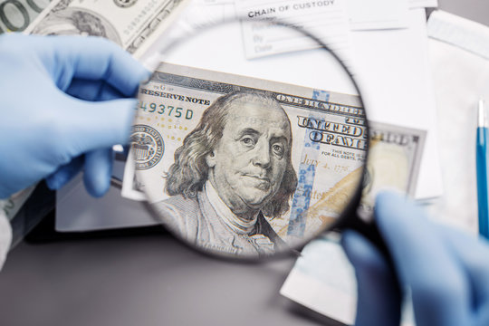 Policewoman With Magnifying Glass Checks Suspicious Money.