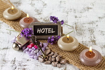 Hotel concept with door key and burning candles