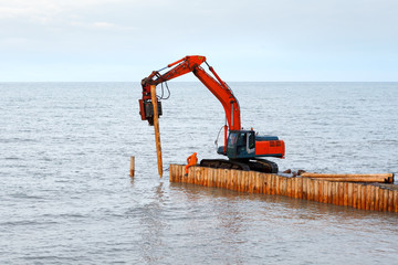 palification piles of larch. Construction of wooden breakwaters at sea
