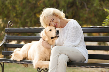 Senior woman sitting on bench with dog