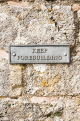 Keep forebuilding iron plaque on traditional stone wall