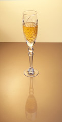 Glass of sparkling shampagne wine on a gold background