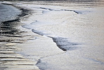 increspature blu sulla superficie dell'acqua a riva sulla spiaggia in inverno