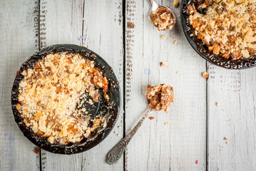 Freshly baked crumble with berries and apples on a white wooden table, top view. copy space