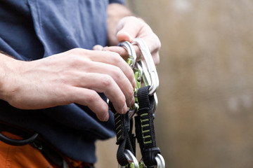 Young man preparing the equipment for climbing.