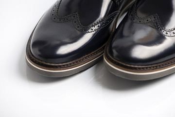Fototapeta na wymiar Black leather shiny boot sobre fondo blanco. Horizontal studio shot