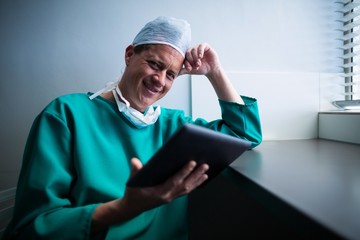 Portrait of male surgeon using digital tablet