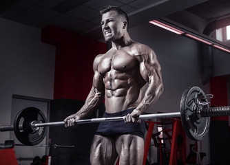 Fototapeta na wymiar Muscular bodybuilder guy doing exercises with dumbbell