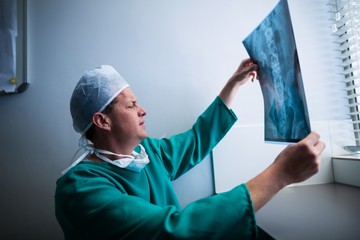 Surgeon sitting at window and checking x-ray