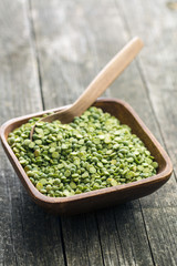 Green split peas in wooden bowl.
