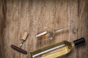 Glass bottle of wine with corks on wooden table background