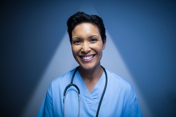 Portrait of female nurse standing in corridor