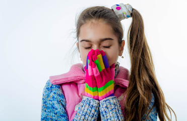 Beautiful little girl in cap and scarf isolated on white. 

