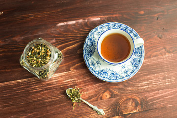 cup of tea on wooden background and tea leaves