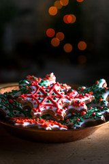 Xmas composition. Gingerbread cookies in the shape of snowflakes in a copper bowl on a dark bokeh background. 