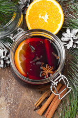 Christmas drink with orange fruit, anise, cinnamon and cloves on wooden table