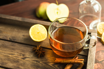cup of tea on wooden background with cinnamon, anise stars