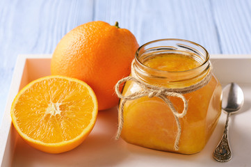 Naklejka na ściany i meble Orange jam in glass jar on wooden background.
