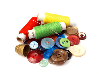 colored skeins of thread with a needle lying on the old button-down next to the confidant