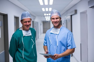 Portrait of surgeon and nurse standing in corridor
