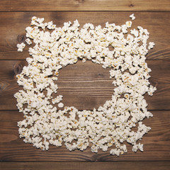 Frame of popcorn on wooden background