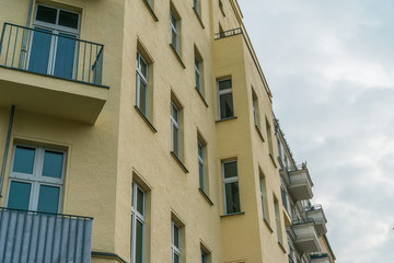 beautiful yellow corner house with balconies and blue windows