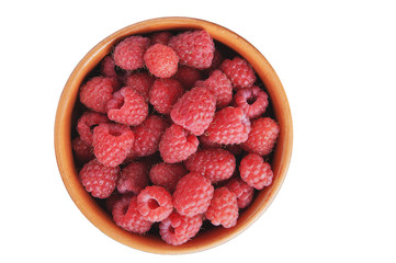 Red ripe raspberries in clay bowl isolated on white. View from above.