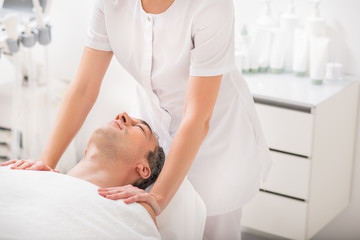 Relaxed male client enjoying massaging treatment