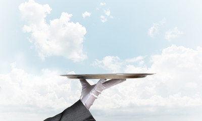 Waiter holding empty silver platter ready for product or item placement