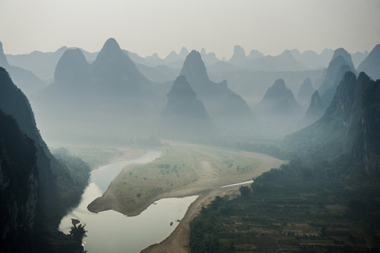 River flowing against mountain during foggy weather