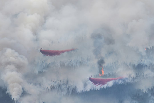 High angle view of seaplane discharging water on forest fire