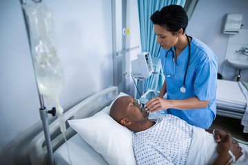 Nurse adjusting oxygen mask on patient mouth