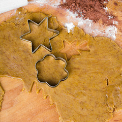 Cookies forms and gingerbread dough on wooden pastry board