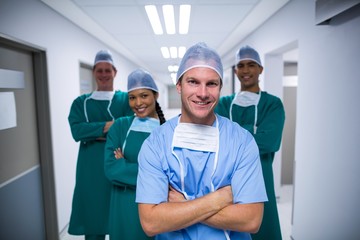 Portrait of nurse and surgeons standing in corridor