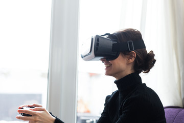 Woman with gamepad and VR set