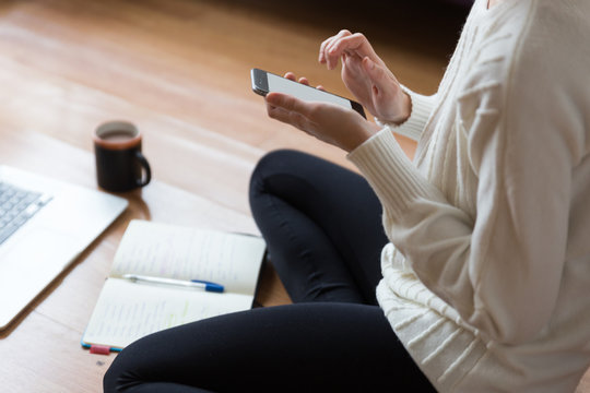 Woman using her phone on the floor