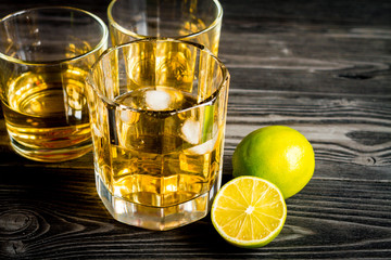 glass of whiskey on dark wooden background